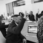 Vote en assemblée générale de copropriété — copropriétaires votant à main levée lors d'une réunion