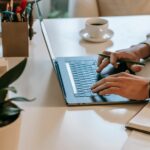 Une personne saisit des informations sur un ordinateur portable