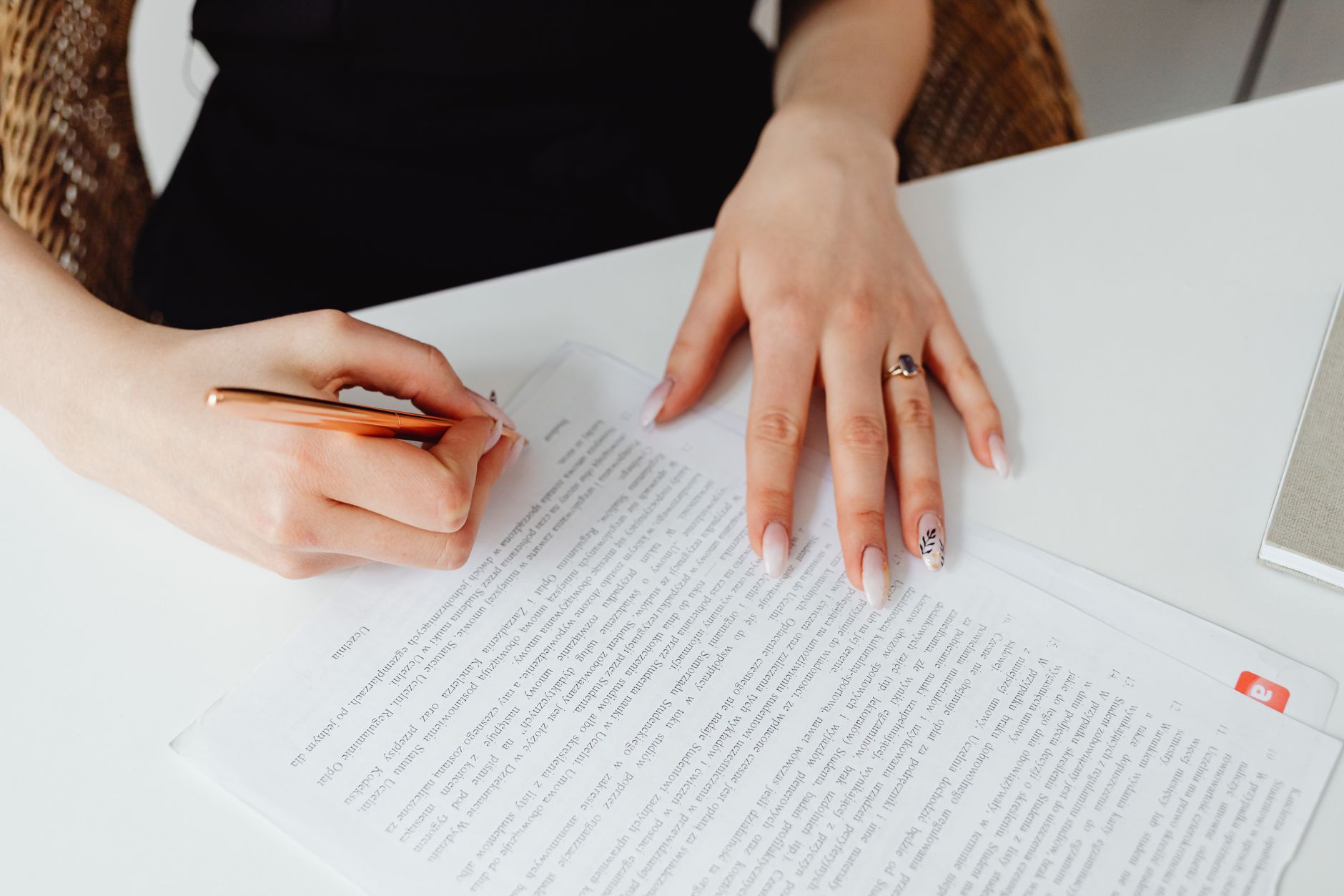 Une femme signe un document posé sur un bureau